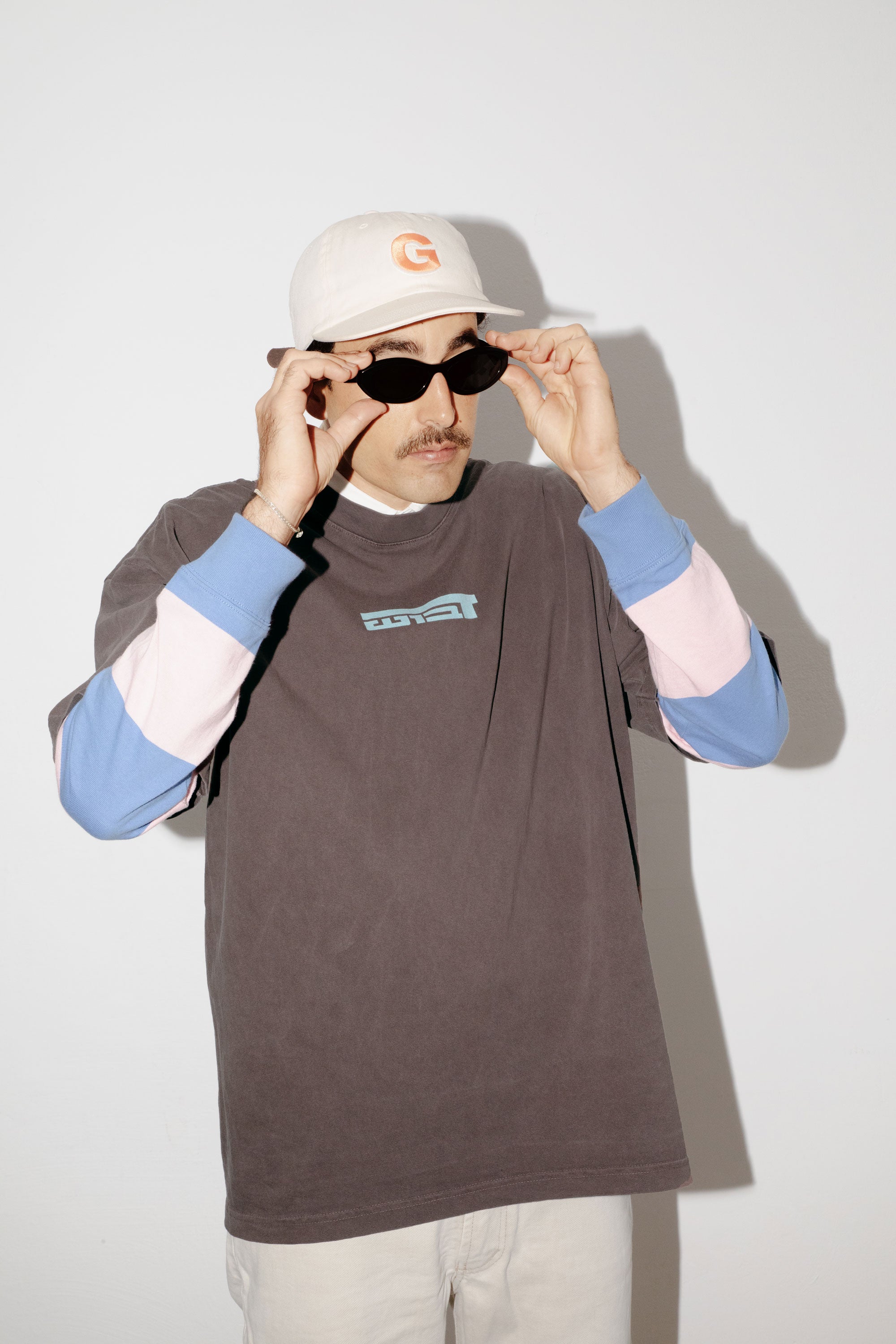 A model wearing an oversized DABUSH t-shirt in washed brown, made from 100% cotton.
דוגמן לובש טישרט אוברסייז של דבוש בצבע חום שטוף, עשויה 100% כותנה עם לוגו בצבע תכלת.