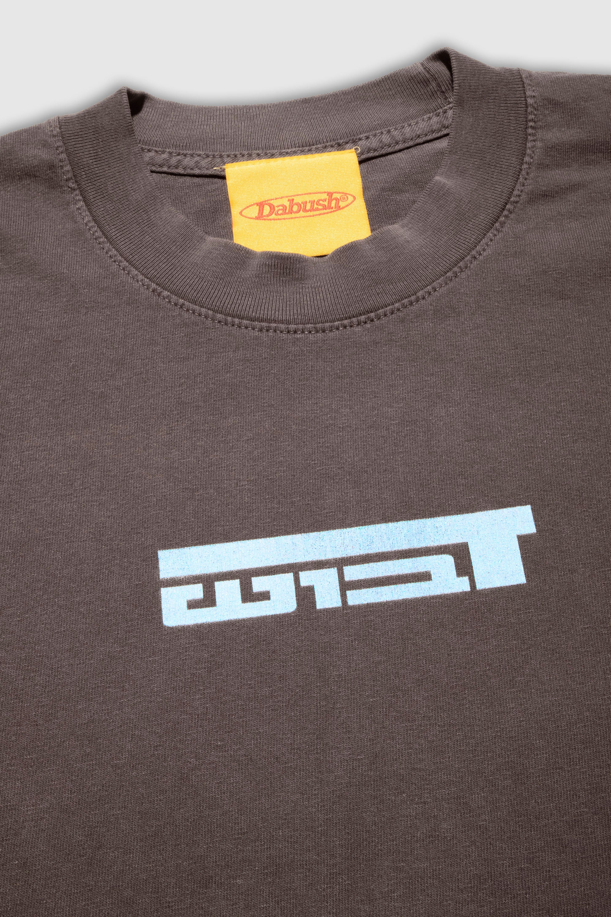 Close-up of the soft cotton texture and graphics on a washed brown oversized t-shirt by DABUSH.