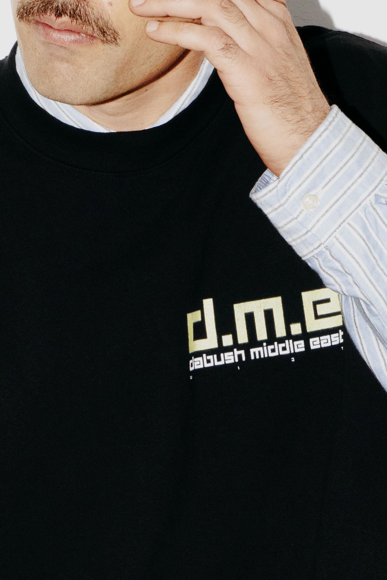 Close-up of a model wearing the soft cotton texture and graphics on a black oversized t-shirt by DABUSH.
