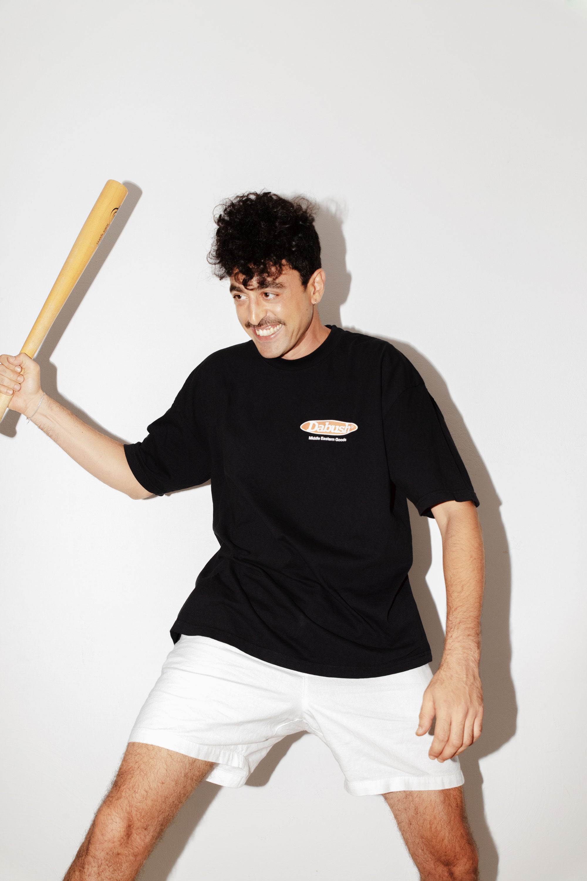 A model wearing an oversized DABUSH t-shirt in black, made from 100% cotton.

דוגמן לובש אוברסייז טישרט של דבוש בצבע שחור, עשויה 100% כותנה עם לוגו.
